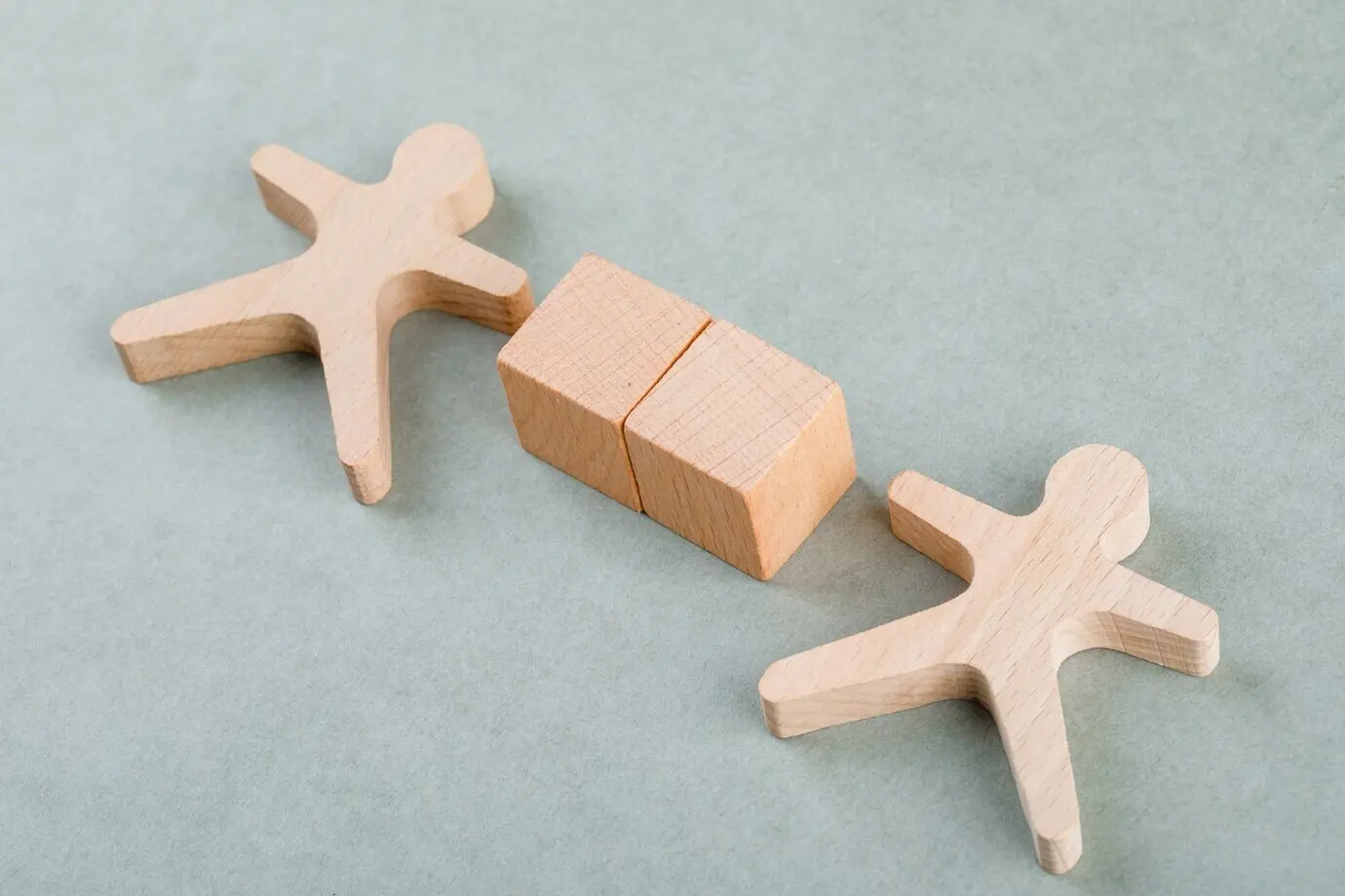 Employee search concept with wooden blocks and a wooden human figure.